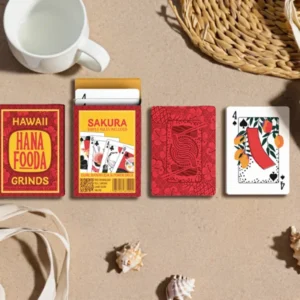 overhead lifestyle shot of the cards and box on sand with common tropical items like sea shells
