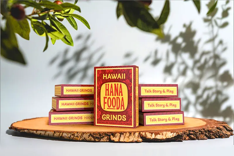 Stack of Hanafooda Specialty cards on a wooden plater surrounded by green branches